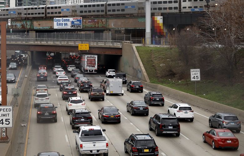 FILE – Traffic flows along Interstate 90 highway as a Metra suburban commuter train moves along an elevated track in Chicago on March 31, 2021.   With upcoming data showing traffic deaths soaring, the Biden administration is steering $5 billion in federal aid to cities and localities to address the growing crisis by slowing down cars, carving out bike paths and wider sidewalks, and nudging commuters to public transit.  (AP Photo/Shafkat Anowar, File) NYCD201 NYCD201