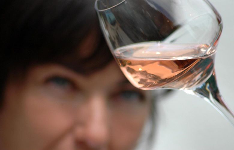 A woman holds up a glass of a Cotes de Provence rose wine to judge its color. A traditional rose is known for its delicate structure. French vinters are angry about an E.U. rule change would let a blend of red and white wines be sold as rose starting Aug. 1. Illustrates FRANCE-ROSE (category i), by Edward Cody (c) 2009, The Washington Post. Moved Monday, May 4, 2009. (MUST CREDIT: Francois Millo,  Interprofessional Provence Wines Council.)
