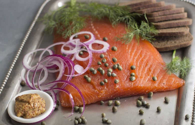 This Aug. 18, 2014 photo shows do it yourself cured salmon in Concord, N.H. Gravlax , as cured salmon is known by its Nordic name, generally is made by dry-curing fillets of salmon in a blend of sugar, kosher salt, fresh dill and a variety of other seasonings. The process extracts moisture from the flesh of the salmon, producing a smooth, yet meaty texture and a wonderfully salty-sweet flavor. (AP Photo/Matthew Mead)