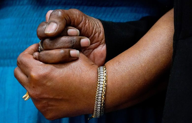 The daughters of Ruth Whitfield, a victim of shooting at a supermarket, Angela Crawley, left, and Robin Harris, hold hands during a news conference in Buffalo, N.Y., Monday, May 16, 2022. (AP Photo/Matt Rourke) NYMR123 NYMR123