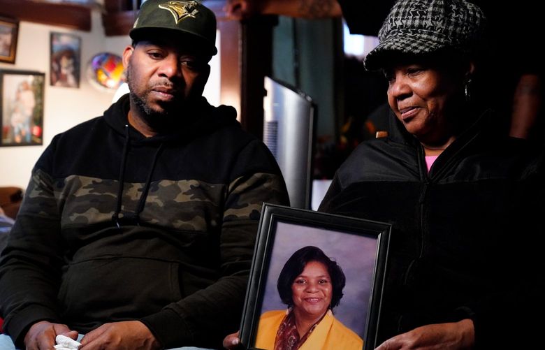 Wayne Jones, left, looks on as his aunt JoAnn Daniels, holds a photograph of his mother Celestine Chaney, who was killed in Saturday’s shooting at a supermarket, during an interview with The Associated Press in Buffalo, N.Y., Monday, May 16, 2022. (AP Photo/Matt Rourke) NYMR132 NYMR132