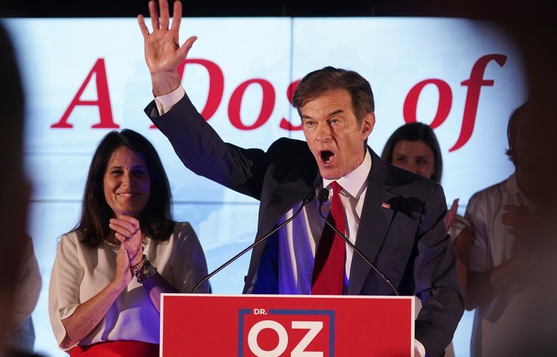Mehmet Oz, a Republican candidate for U.S. Senate in Pennsylvania, right, waves in front of his wife, Lisa, while speaking at a primary night election gathering in Newtown, Pa., Tuesday, May 17, 2022. (AP Photo/Seth Wenig) PASW105 PASW105