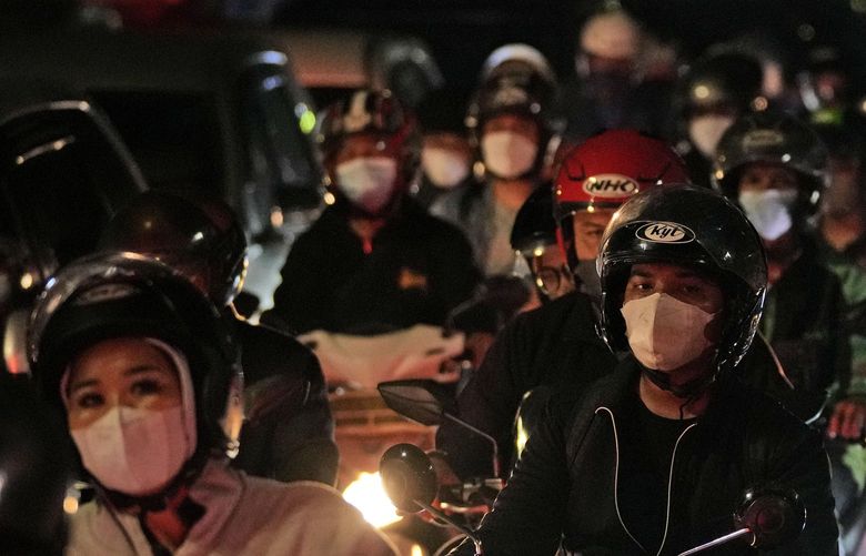 Motorists are seen wearing masks during rush hour traffic in Jakarta, Indonesia, Tuesday, May 17, 2022. Indonesia will lift its outdoor mask mandate because its COVID-19 outbreak appears to be waning, President Joko Widodo said Tuesday. (AP Photo/Dita Alangkara) DA102 DA102
