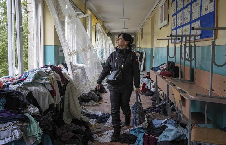 FILE – School official Iryna Homenko walks in the hall of a school damaged by an airstrike from Russian forces in Chernihiv, Ukraine, Wednesday, April 13, 2022. In Chernihiv alone, the city council said only seven of the city’s 35 schools were unscathed. Three were reduced to rubble. (AP Photo/Evgeniy Maloletka, File) NY735 NY735