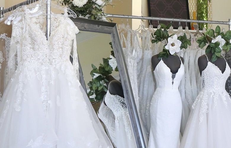 FILE – Wedding dresses are displayed at a bridal shop in East Dundee, Ill., on Feb. 28, 2020. Far fewer Americans were married during the first year of the COVID-19 pandemic, with the number of U.S. marriages in 2020 being the lowest recorded since 1963, according to statistics released by the Centers for Disease Control and Prevention on Tuesday, May 17, 2022. (AP Photo/Teresa Crawford, File) NY777 NY777