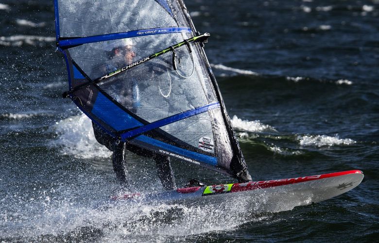 Under extremely windy conditions on Lake Washington, Alan Allegret bolts onto the water with his windfoil during weekly windsurf races off New Castle Beach Park in Bellevue, Wednesday, May 18, 2022 in Bellevue. According to City League Series race organizer Greg Mejlaender, the winds were anywhere between 20 to 40 miles per hour. “If anyone gets to the buoy and back we’ll crown them champion and the rest of us are in survival mode,” joked Mejlaender.