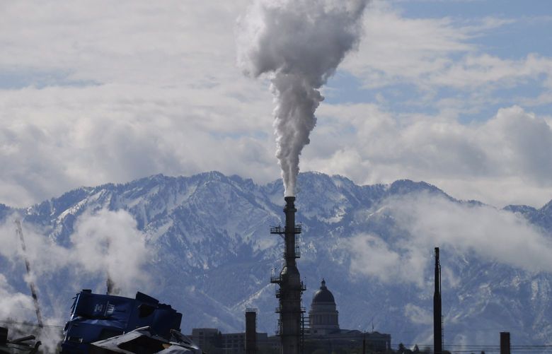 The Utah State Capitol, rear, is shown behind an oil refinery on Thursday, May 12, 2022, in Salt Lake City. A growing number of Republican-led states with economies that rely heavily on fossil fuels are pushing back against shifts in the financial industry to consider new factors such as environmental risk in their investment decisions. (AP Photo/Rick Bowmer) UTRB106 UTRB106