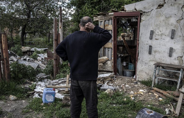 A resident inspects the damage to his sister’s home in the village of Vilkhivka, which was occupied by Russian forces, east of Kharkiv, Ukraine, May 19, 2022. (Finbarr O’Reilly/The New York Times) XNYT31 XNYT31