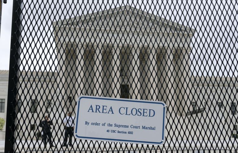 The U.S. Supreme Court is seen behind a fence who stands around the building on Thursday, May 5, 2022 in Washington. A draft opinion suggests the U.S. Supreme Court could be poised to overturn the landmark 1973 Roe v. Wade case that legalized abortion nationwide, according to a Politico report released Monday. Whatever the outcome, the Politico report represents an extremely rare breach of the court’s secretive deliberation process, and on a case of surpassing importance. (AP Photo/Jose Luis Magana) DCJL105 DCJL105