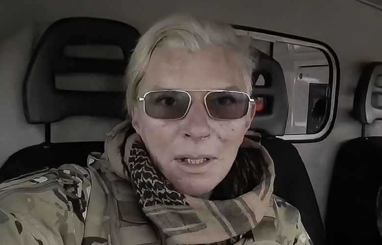Yuliia Paievska, known as Taira, and her driver Serhiy sit in a vehicle in Mariupol, Ukraine on March 9, 2022. She last appeared on March 21 on Russian television as a captive, handcuffed and with bruises on her face. Using a body camera, she recorded her team’s frantic efforts to bring people back from the brink of death. (Yuliia Paievska via AP) NYAG912 NYAG912