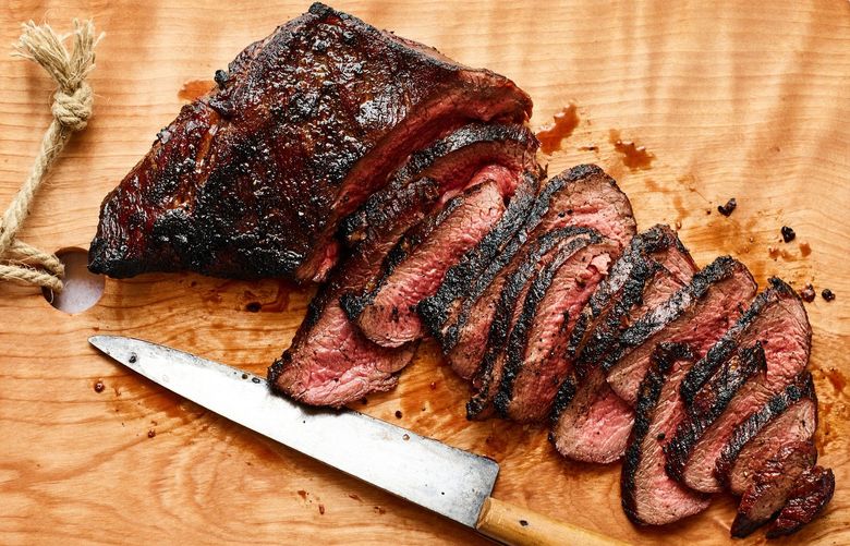 Reverse-seared steak in Santa Barbara, Calif., May 2, 2022. Reverse-searing allows thick cuts of steak, such as tri-tip, top round and porterhouse, to cook to an even doneness and develop a charred crust. Food styled by Carrie Purcell. (Andrew Purcell/The New York Times)