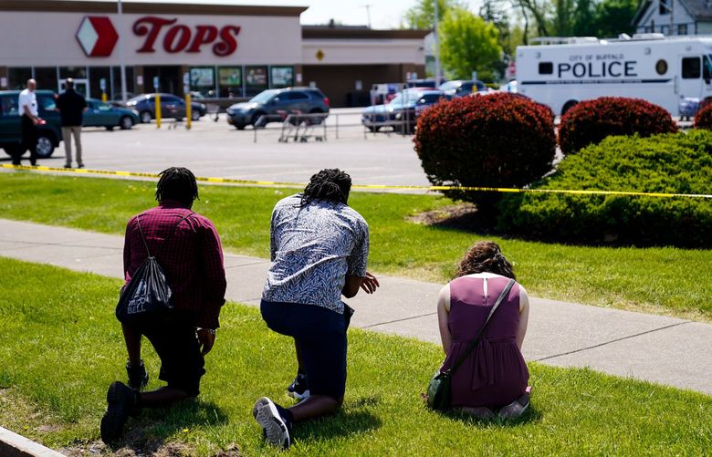 FILE – People pray outside the scene of a shooting where police are responding at a supermarket, in Buffalo, N.Y., May 15, 2022. When police confronted Payton Gendron, the white man suspected of killing 10 Black people at the supermarket, he had an AR-15-style rifle and was cloaked in body armor. Yet officers talked to Gendron, convinced him to put down his weapon and arrested him without firing a single shot. Some people are asking why that type of treatment hasn’t been afforded to Black people in encounters where they were killed over minor traffic infractions, or no infractions at all. (AP Photo/Matt Rourke, File) NYB201 NYB201