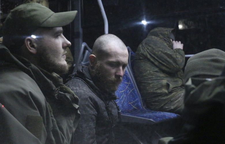 Ukrainian servicemen sit in a bus after leaving Mariupol’s besieged Azovstal steel plant, near a penal colony, in Olyonivka, in territory under the government of the Donetsk People’s Republic, eastern Ukraine, Friday, May 20, 2022. (AP Photo)