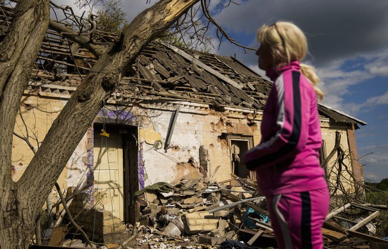 Iryna Martsyniuk, 50, stands next to her heavily damaged house after a Russian bombing in Velyka Kostromka village, Ukraine, Thursday, May 19, 2022. Martsyniuk and her three young children were at home when the attack occurred in the village, a few kilometres from the front lines, but they all survived unharmed. (AP Photo/Francisco Seco) FS107 FS107