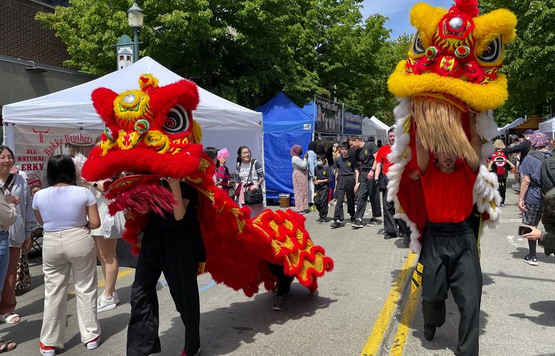 Members of NW Kung Fu and Fitness perform a traditional Chinese Lion Dance down The Ave (University Way NE) during the U District Street Fair, Sunday, May 22, 2022 in Seattle. According to the event’s website: “The U District Street Fair returns for its 51st year during the weekend of May 21-22, kicking-off Seattle’s summer event season with a 10 block-long arts and crafts fair that takes over University Way (a.k.a. “The Ave”) and Brooklyn Ave NE. The two-day event will also feature free live music and performances, and over 40 food trucks and booths.”