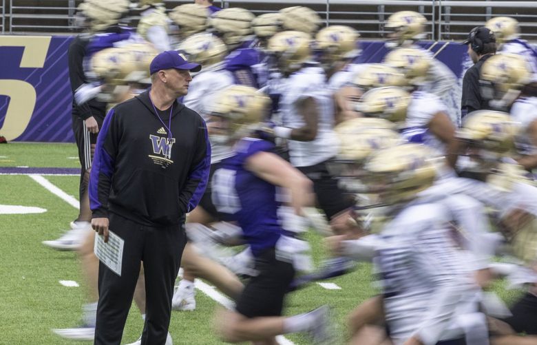 Wed. March 30, 2022. First UW football spring practice. UW coach Kalen Deboer walking among players and staff s they perform early morning warmups. 219945