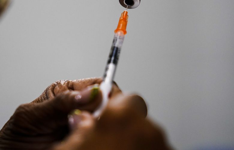 FILE – A syringe is prepared with the Pfizer COVID-19 vaccine at a vaccination clinic at the Keystone First Wellness Center in Chester, Pa., Dec. 15, 2021. The White House is planning for what it calls “dire†contingencies that could include rationing supplies of vaccines and treatments this fall if Congress doesn’t approve more money for fighting COVID-19. Biden administration officials have been warning for weeks that the country has spent nearly all the money approved for COVID-19 response. (AP Photo/Matt Rourke, File) WX103 WX103