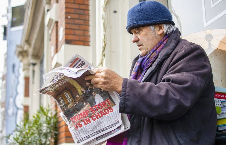 A man reads a newspaper with a headline reading “Trump Plunges U.S. into Chaos” outside a takeaway cafe in the center of Amsterdam, Netherlands, Thursday, Jan. 7, 2021. Congress confirmed Democrat Joe Biden as the presidential election winner early Thursday after a violent mob loyal to President Donald Trump stormed the U.S. Capitol in a stunning attempt to overturn America’s presidential election, undercut the nation’s democracy and keep Trump in the White House. (AP Photo/Peter Dejong) PDJ102