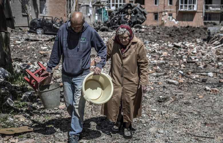 Residents salvage what they can from an apartment complex that was bombed by Russian forces on Monday, May 23, 2022, in the frontline town of Bakhmut in Ukraine’s eastern Donetsk region. As the war in Ukraine lurches toward the three-month mark, President Volodymyr Zelenskyy took his message of unity against Russian aggression to an audience of global business elites on Monday, calling on international leaders at the World Economic Forum to marshal their financial might to further punish Moscow and back Ukraine’s resistance. (Finbarr O’Reilly/The New York Times) XNYT69 XNYT69