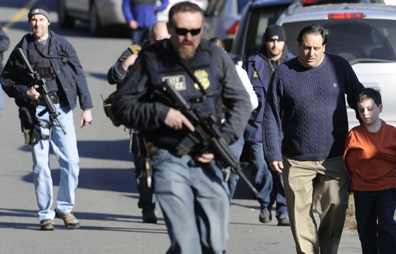 FILE- In this Dec. 14, 2012 file photo, parents leave a staging area after being reunited with their children following a shooting at the Sandy Hook Elementary School in Newtown, Conn. At least 14 children and a teacher were killed in a shooting at a Texas elementary school Tuesday, May 24, 2022, Texas Gov. Greg Abbott said. (AP Photo/Jessica Hill, File) NYDD206 NYDD206