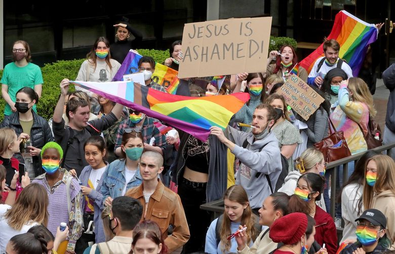Seattle Pacific University students and faculty assemble outside Demaray Hall on the university campus, tuesday, May 24, 2022 stage a walkout to protest the Board of Trustees deciding to maintain a discriminatory hiring policy against people in same-sex relationships. 220475