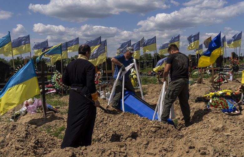 Undertakers lower the coffin of Ukrainian serviceman Oleksander Matyukhin, 32, in Kharkiv, eastern Ukraine, Monday, May 23, 2022. (AP Photo/Bernat Armangue) BA110 BA110