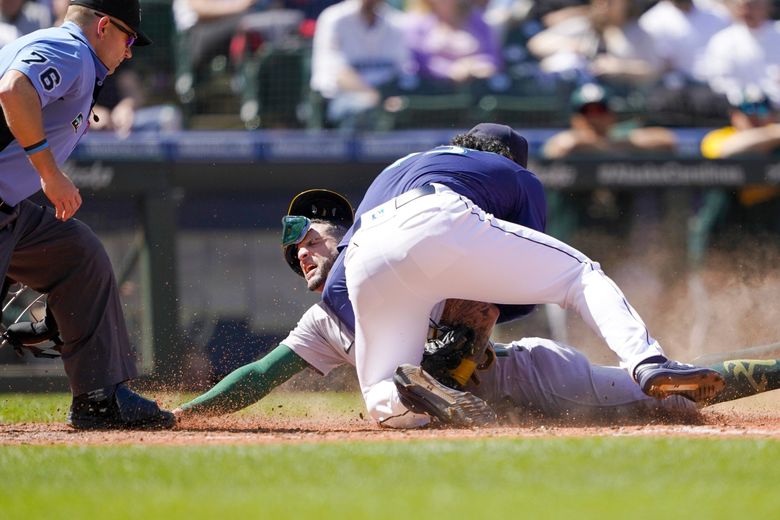 Seattle Mariners pitcher Andres Munoz tags out Oakland Athletics’ Luis Barrera at home plate during the seventh inning, Wednesday, May 25, 2022, in Seattle. (Ted S. Warren / AP)