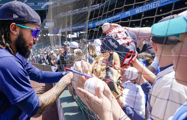 Seattle Mariners shortstop J.P. Crawford signs autographs for young fans before a baseball game against the Oakland Athletics, Wednesday, May 25, 2022, in Seattle. (AP Photo/Ted S. Warren) WATW105