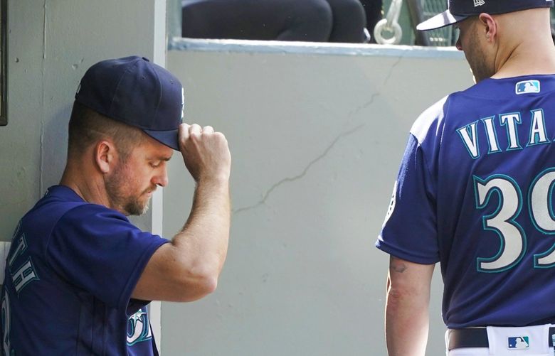Seattle Mariners pitching coach Pete Woodworth, left, and major league field coordinator Carson Vitale (39) linger in the dugout after the team’s baseball game against the Oakland Athletics, Wednesday, May 25, 2022, in Seattle. The Athletics won 4-2. (AP Photo/Ted S. Warren) WATW123