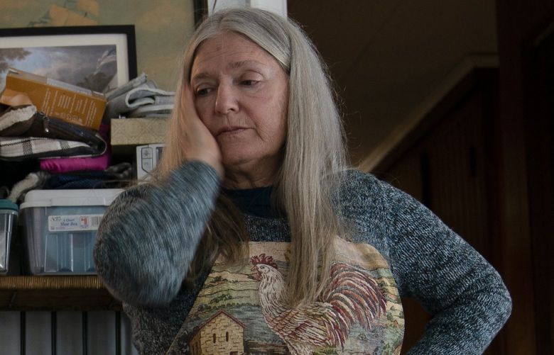 FILE – Nancy Rose, who contracted COVID-19 in 2021 and continues to exhibit long-haul symptoms including brain fog and memory difficulties, pauses while organizing her desk space, Tuesday, Jan. 25, 2022, in Port Jefferson, N.Y. Rose, 67, said many of her symptoms waned after she got vaccinated, though she still has bouts of fatigue and memory loss. A report from the Centers for Disease Control and Prevention released on Wednesday, May 25, 2022, found that up to a year after an initial coronavirus infection, 1 in 4 adults aged 65 and older had at least one potential long COVID health problem, compared with 1 in 5 younger adults. (AP Photo/John Minchillo) NY858 NY858