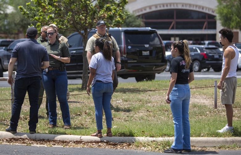 A law enforcement officer tells people Tuesday afternoon, May 24, 2022, that Uvalde High School is secure after a school shooting at the nearby Robb Elementary School in Uvalde, Texas. (William Luther/San Antonio Express-News/Zuma Press/TNS) 48750442W 48750442W