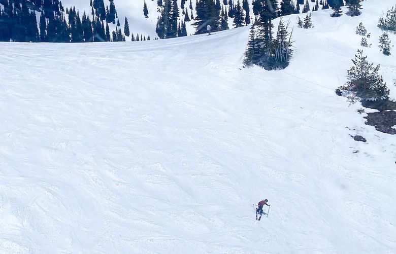 A skier enjoys a run called Sunnyside alone on a blue bird spring day at Crystal Mountain ski resort, May 22, 2022. This photo was taken from the Mount Rainier Gondola which is open for sightseeing tours 9 a.m.-5 p.m. on Fridays, Saturdays and Sundays.