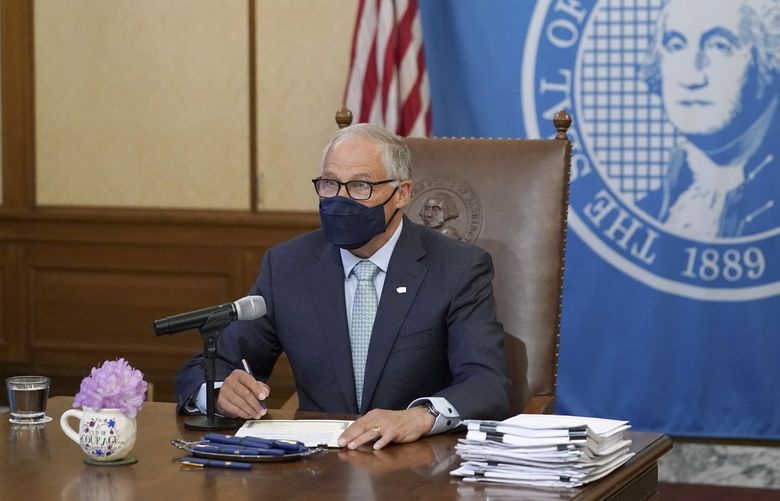 Washington Gov. Jay Inslee speaks Wednesday, May 12, 2021, at the Capitol in Olympia, Wash., before signing a bill into law that prohibits openly carrying guns and other weapons at the state Capitol and protests statewide. (AP Photo/Ted S. Warren)