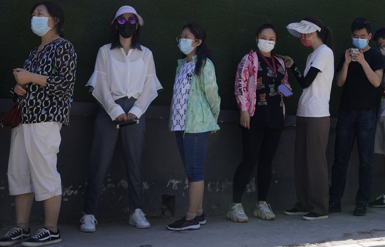 Residents wearing masks line up for mass COVID test, Friday, May 27, 2022, in Beijing. (AP Photo/Ng Han Guan) 