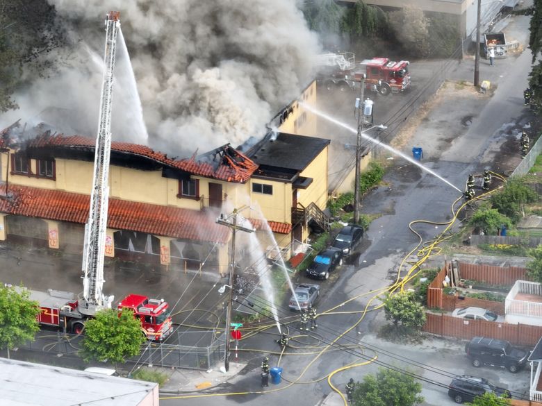 An aerial view of firefighters battling a blaze Friday afternoon at the former Borracchini’s Bakery & Mediterranean Market building near Rainier Avenue South and South Walker Street in Seattle. (Daniel Kim / The Seattle Times)