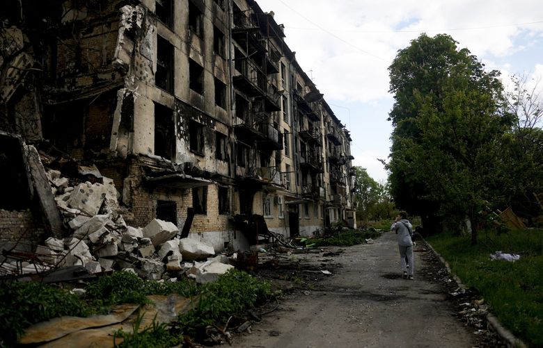 A man walks in front of a damage building ruined by attacks in Hostomel, outskirts Kyiv, Ukraine, Thursday, May 26, 2022. (AP Photo/Natacha Pisarenko) XNP123 XNP123