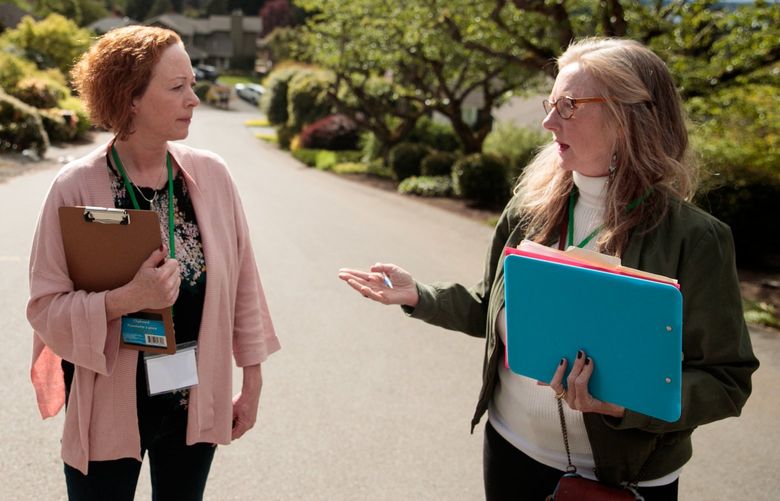 Emily Tadlock, wearing green, and Jenifer Short, wearing pink, both volunteers with the Washington Voter Research Project finish visiting a home in Clyde Hill, Wash. Monday, May 9, 2022. Tadlock and Short visited the home, not in their districts, after a meeting with fellow volunteers in Bellevue.
220344