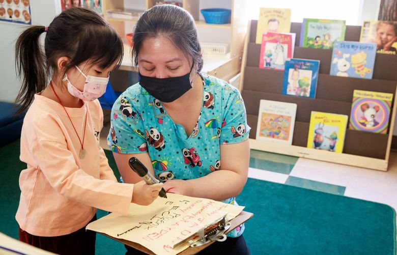 Emma Hu CQ signs her name volunteering for a classroom job with teacher May Sta Cruz CQ during Head Start class time at the Denise Louie Education Center in Seattle’s Chinatown-International District Wednesday, May 25, 2022.
*EDITORS NOTE: Teacher confirmed all kids in this class are okay being photographed. 220474