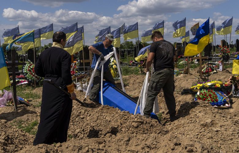 Undertakers lower the coffin of Ukrainian serviceman Oleksander Matyukhin, 32, in Kharkiv, eastern Ukraine, Monday, May 23, 2022. (AP Photo/Bernat Armangue) XAZ910 XAZ910