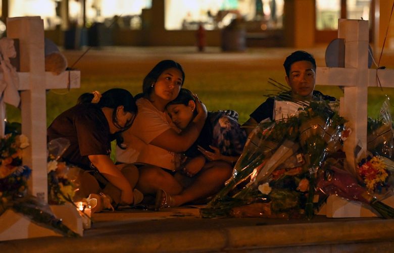 People gather at a memorial for the slain Robb Elementary School students and teachers at the City of Uvalde Town Square. MUST CREDIT: Washington Post photo by Joshua Lott.