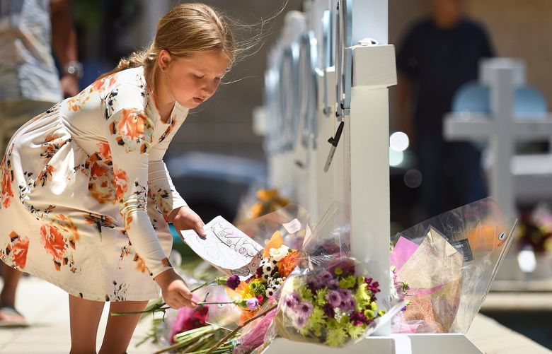 Kymber Guzman, 8, places flowers at a memorial for the victims of a mass shooting in Uvalde, Texas, on Thursday, May 26, 2022. Nineteen students and two teachers died when a gunman opened fire in a classroom Tuesday. (Wally Skalij/Los Angeles Times/TNS) 49298405W 49298405W