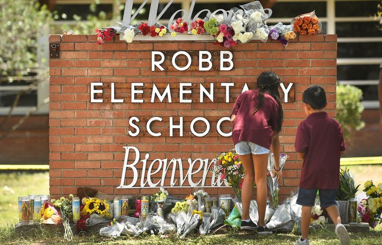 Family members who lost a sibling place flowers outside Robb Elementary School in Uvalde, Texas, on Wednesday, May 25, 2022. (Wally Skalij/Los Angeles Times/TNS) 49305400W 49305400W