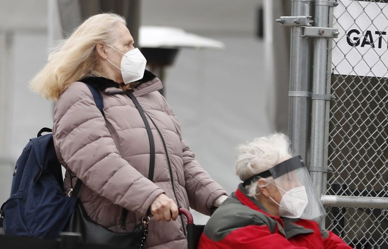 CORRECTS MONTH TO MARCH NOT FEBRUARY – Senior citizens exit the United Center mass COVID-19 vaccination site on Wednesday, March 10, 2021, in Chicago. The site expects to administer 6,000 shots per day at full capacity and will remain open seven days a week for eight weeks. (AP Photo/Shafkat Anowar)