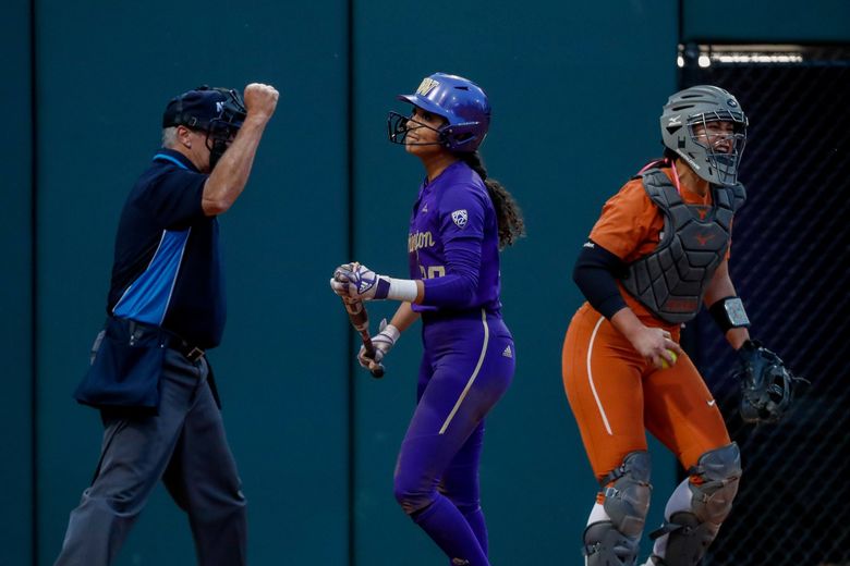 The umpire signals the final out of Game 2 as Texas catcher Mary Iakopo celebrates after Washington’s Kinsey Fiedler strikes out Sunday. (Jennifer Buchanan / The Seattle Times)