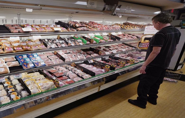 A man browses in the meat department at Lambert’s Rainbow Market, on June 15, 2021 in Westwood, Mass. February food prices were 7.9% higher compared with a year ago and are expected to increase 4.5% to 5.5% in 2022. As a result, it can feel harder than ever to keep grocery spending under control. But budgeting and cooking experts say there are strategies you can apply to save money and make a difference in your household budget. (AP Photo/Charles Krupa)