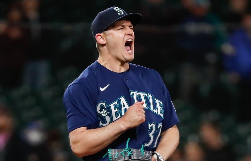 Mariners pitcher Paul Sewald reacts to Blue Jays merchandise being