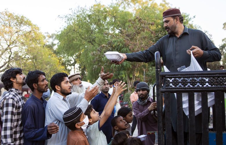 Food is distributed in Islamabad, Pakistan, on April 6, 2022. The economy is drowning in debt and the country’s people are suffering from an unsustainable cost of living. (Saiyna Bashir/The New York Times)