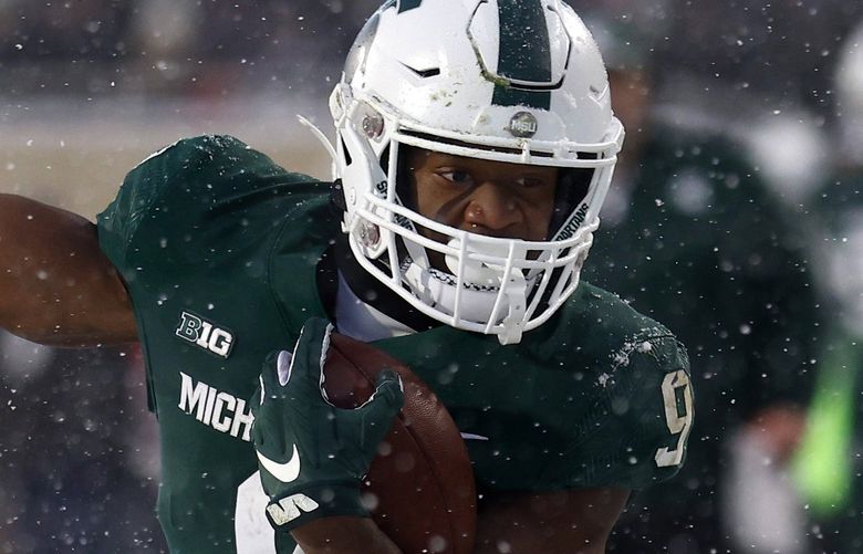 Michigan State’s Kenneth Walker III, right, rushes against Penn State’s Kalen King (4) and Ji’Ayir Brown (16) during an NCAA college football game, Saturday, Nov. 27, 2021, in East Lansing, Mich. (AP Photo/Al Goldis)