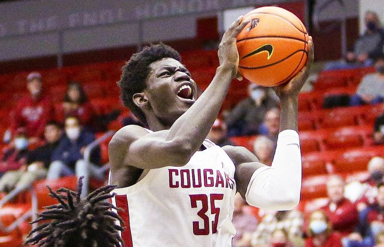 Washington State forward Mouhamed Gueye, center, drives to the basket while defended by Oregon State forwards Glenn Taylor Jr., left, and Maurice Calloo during the second half of an NCAA college basketball game Thursday, March 3, 2022, in Pullman, Wash. Washington State won 71-67. (AP Photo/Young Kwak) WAYK113