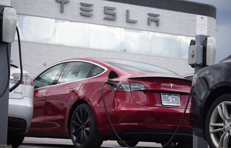 A cybersecurity researcher says the keyless entry on some Tesla models could allow thieves to drive off with the electric vehicles. Shown is a Model 3 sedan plugged in at a Tesla dealership in Littleton, Colo., on June 27, 2021. (David Zalubowski / The Associated Press)